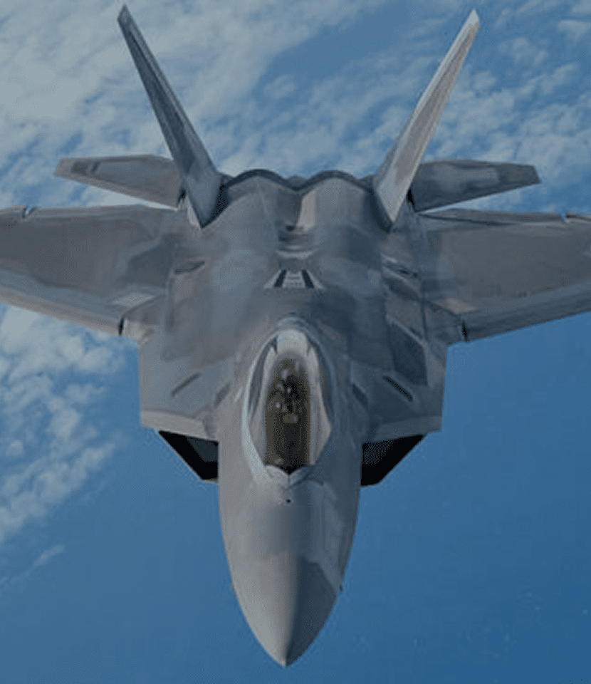 Stealth fighter jet flying in clear sky.